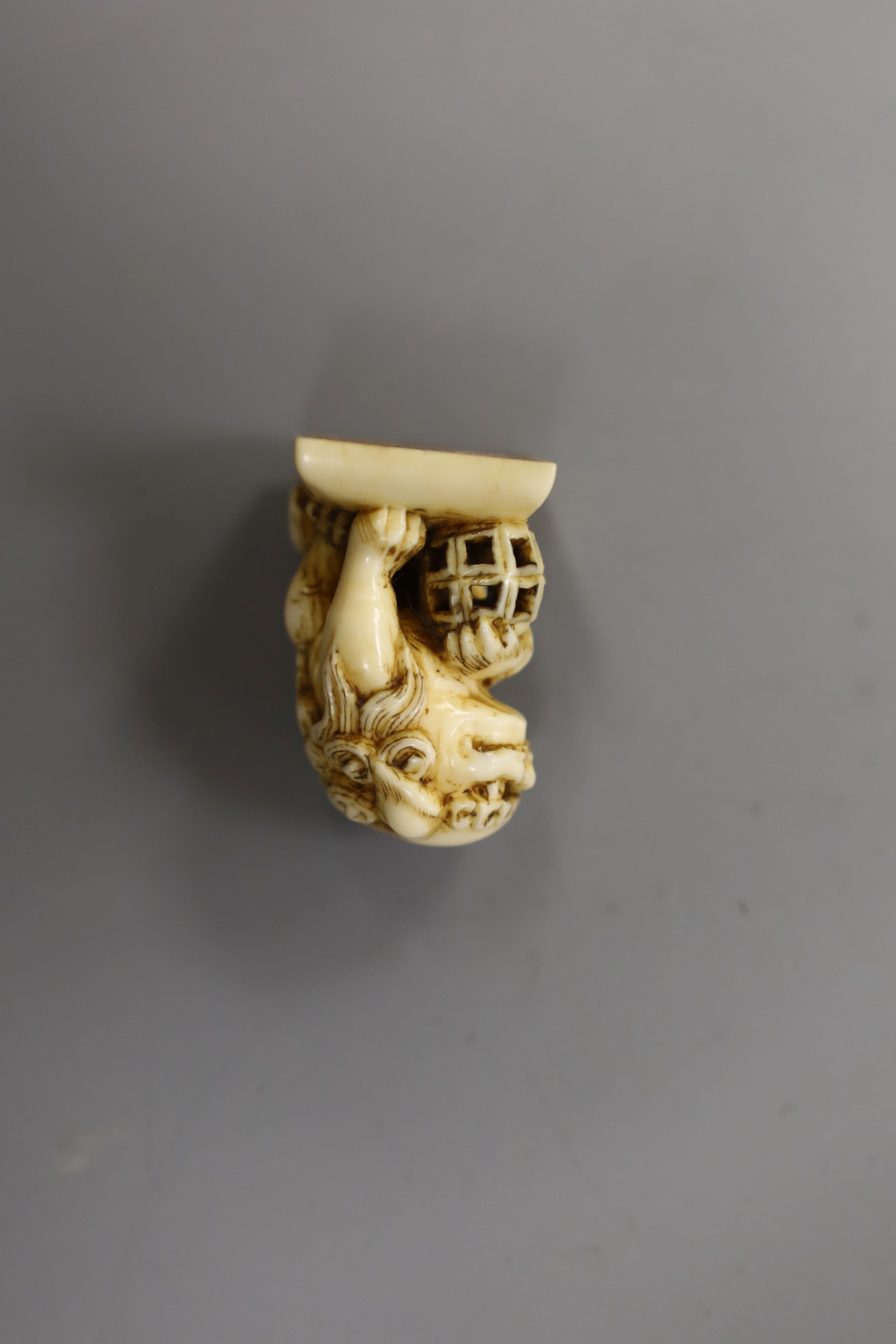 A Chinese or Japanese ivory lion dog 18th/19th century and a Chinese carved nut cup, 19th century. 4cm